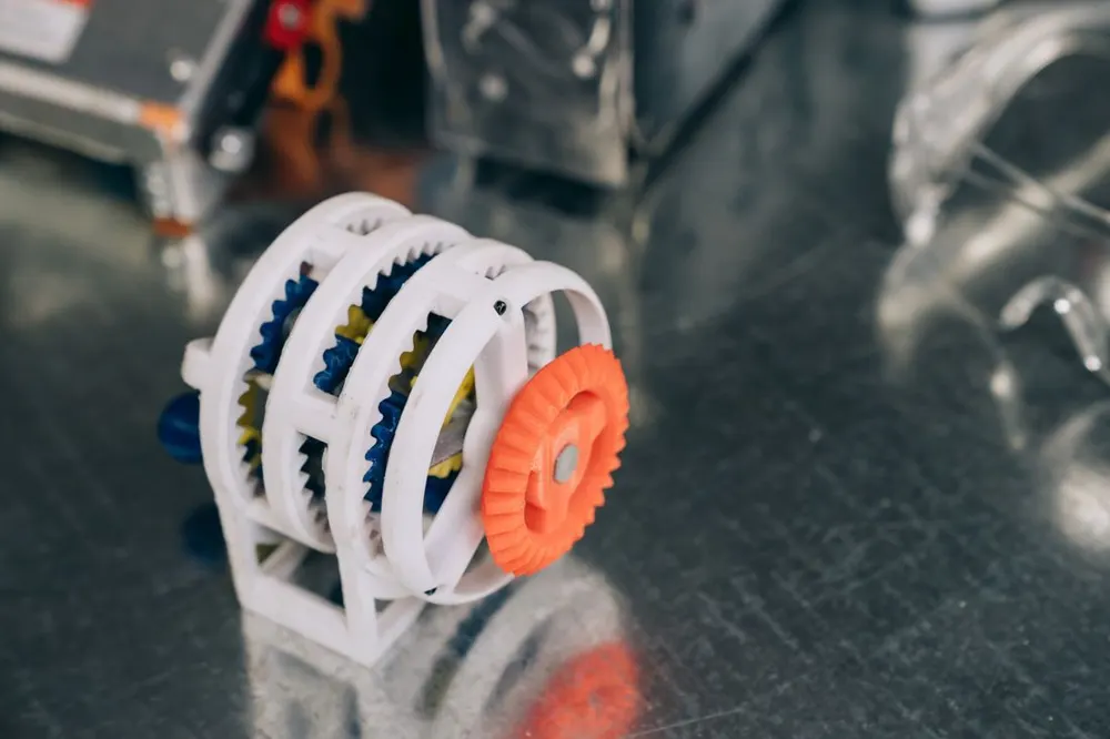 3D printed white and orange gear fidget toy