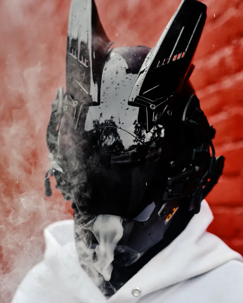Black armoured sci-fi helmet with smoke behind it